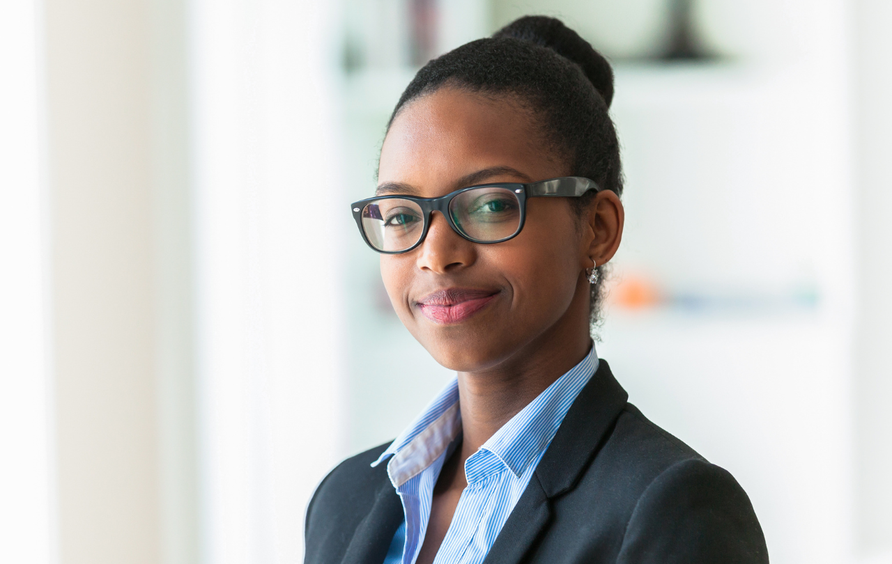 A thoughtful nonprofit or educational leader standing confidently and looking ahead, symbolizing clarity, hope, and forward momentum through coaching