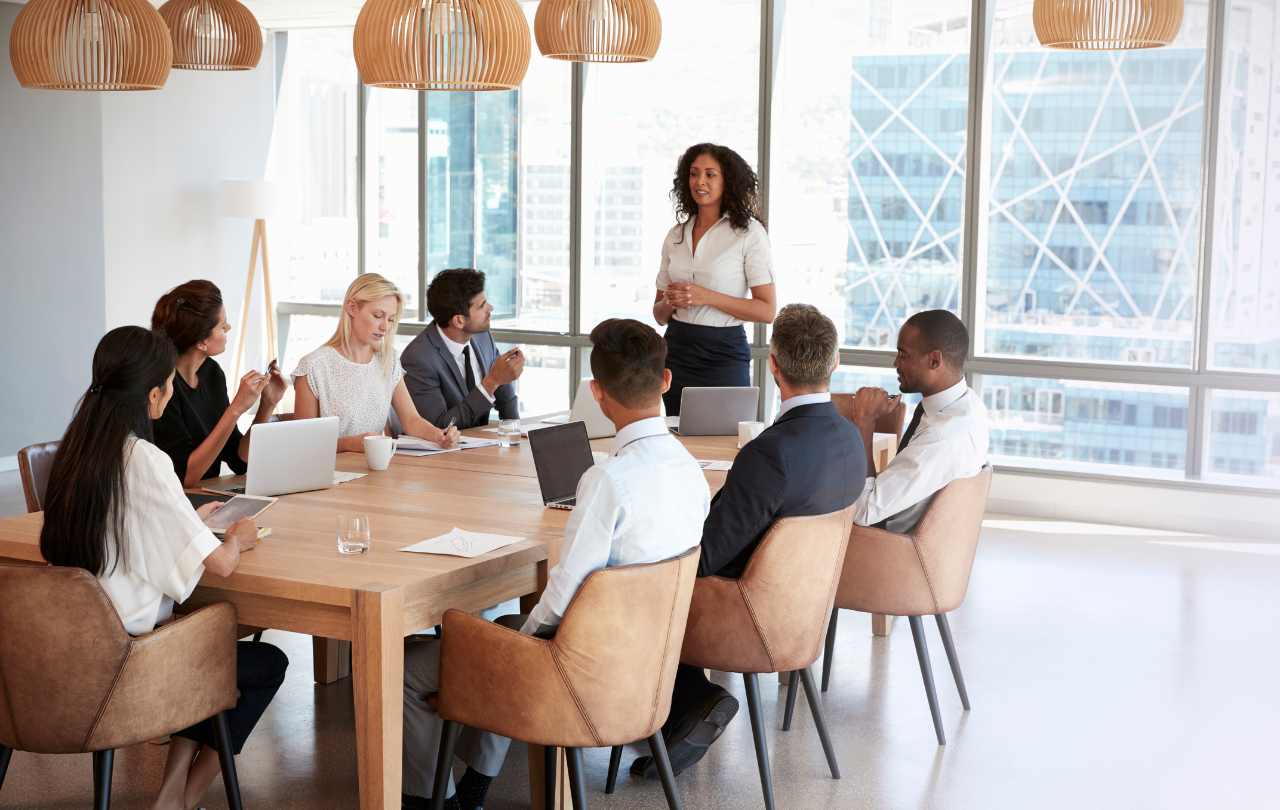 Team lead and team of eight in a meeting